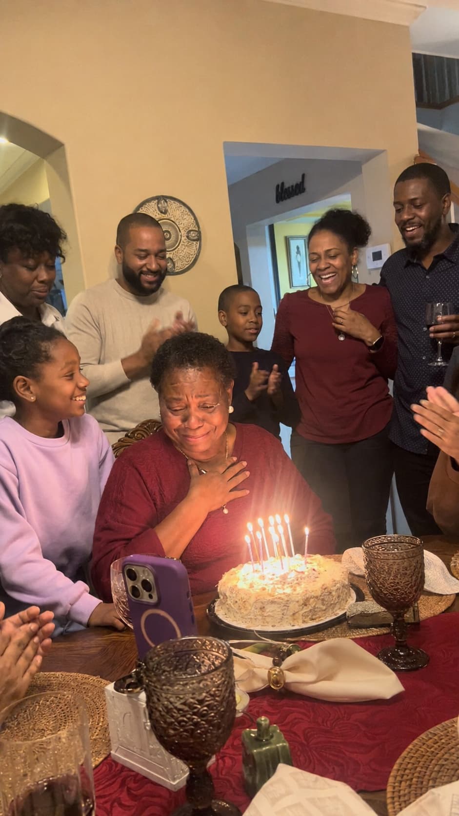Family celebrating a birthday song surprise around a cake