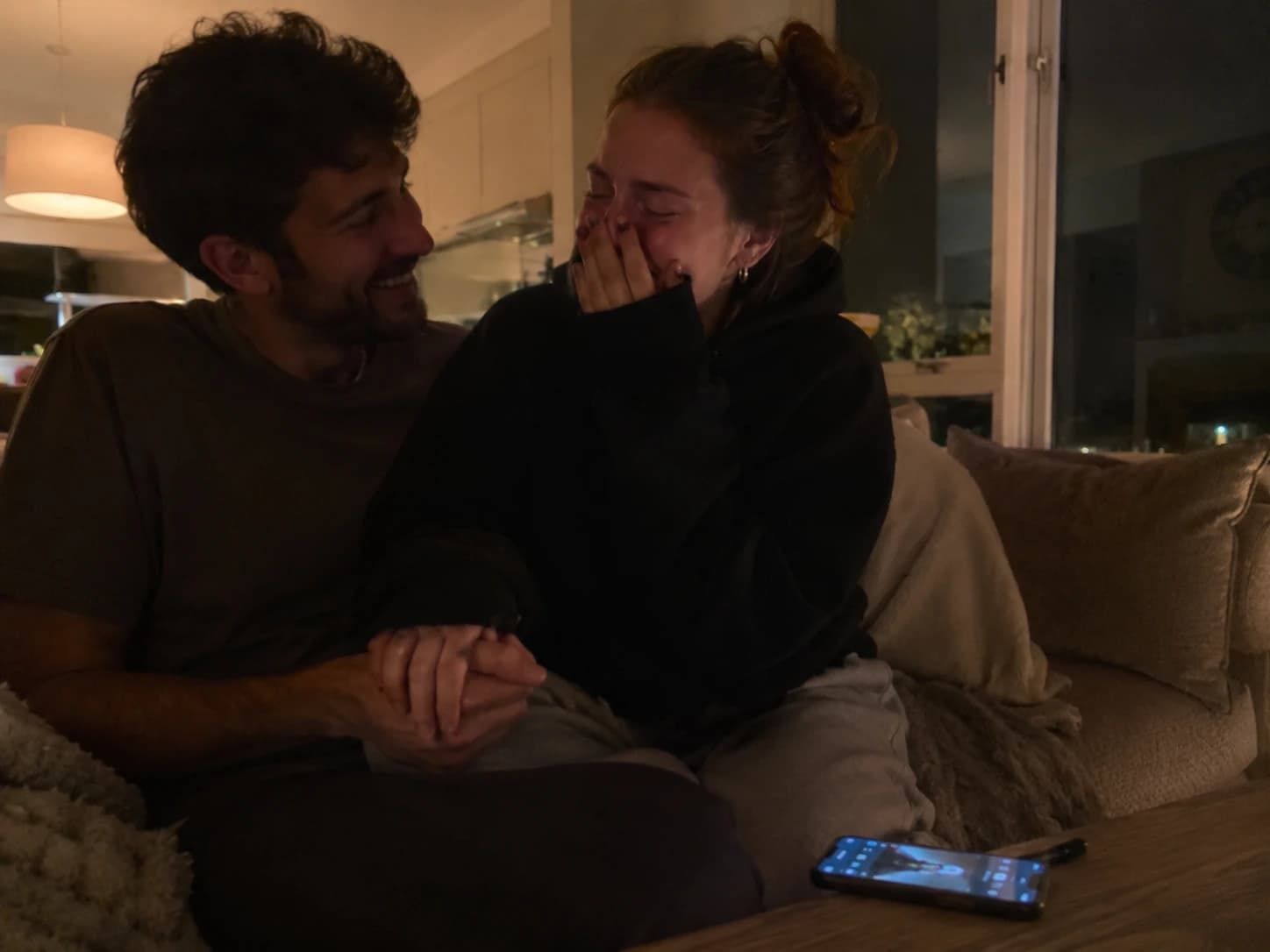 Couple reacting to an anniversary song on the couch